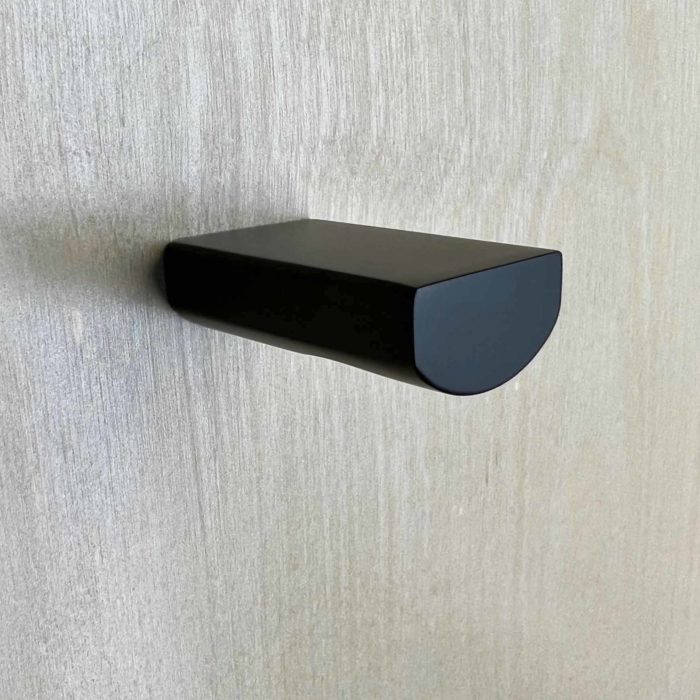 Matte black door knob mounted on a wood door.