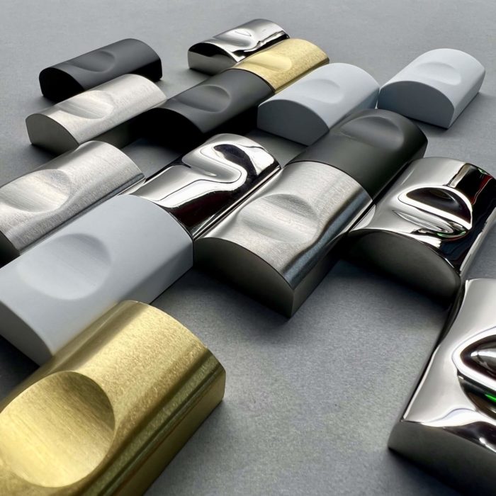 Five metal door pulls finished in the following finishes: matte black, satin white, satin brass, polished stainless and brushed stainless.