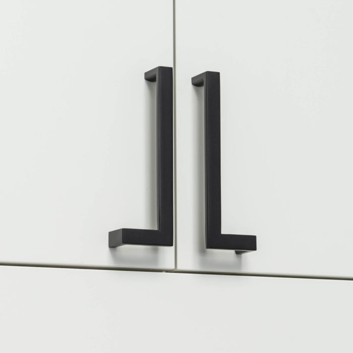 Matte black cabinet pulls mounted on flat panel white cabinet doors