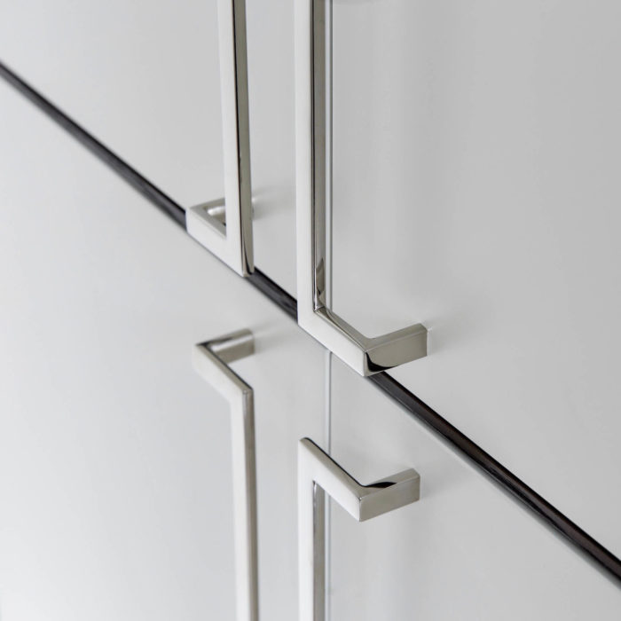 polished stainless steel cabinet pulls mounted on a white door contemporary cabinet