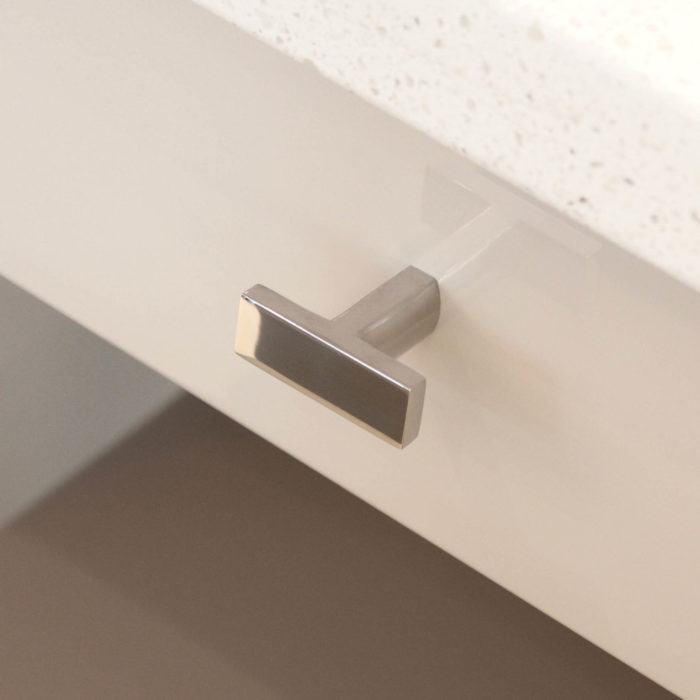 Polished chrome drawer knob mounted on a modern drawer.