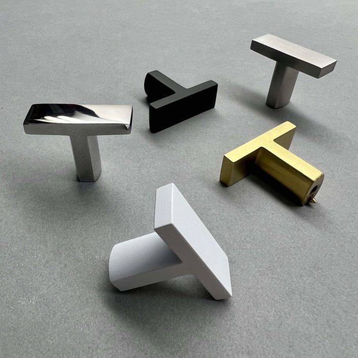 Five cabinet T pulls in the following finishes: matte black, satin white, satin brass, brushed stainless and polished stainless.